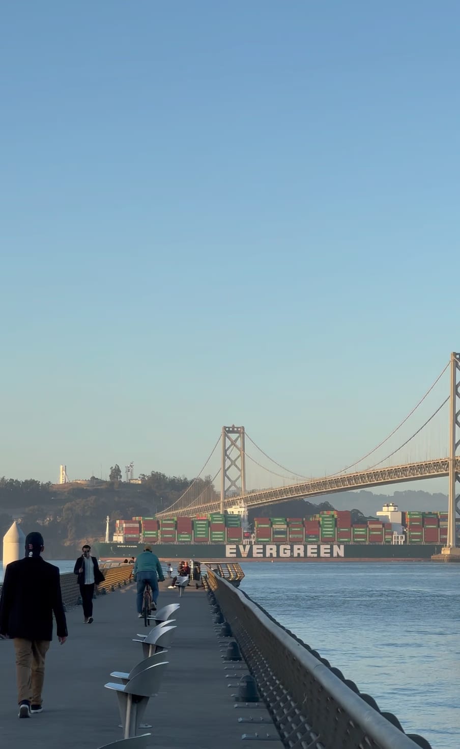 The Embarcadero pier with the Bay Bridge and a container ship in the background